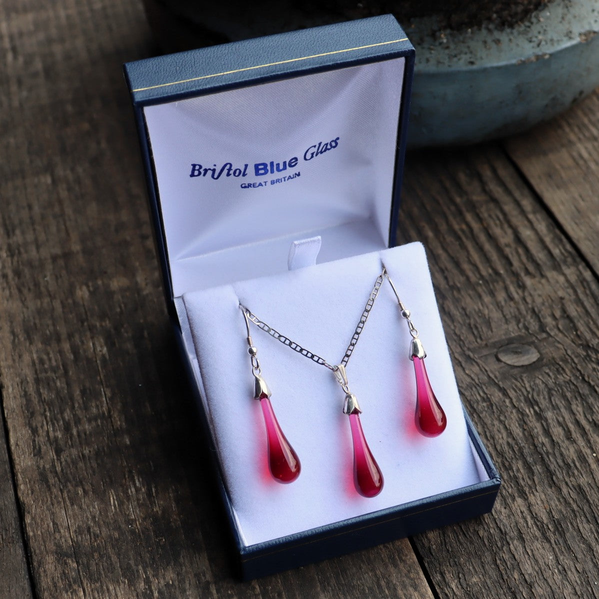Red teardrop jewelry set in a Bristol Blue Glass box on a wooden surface