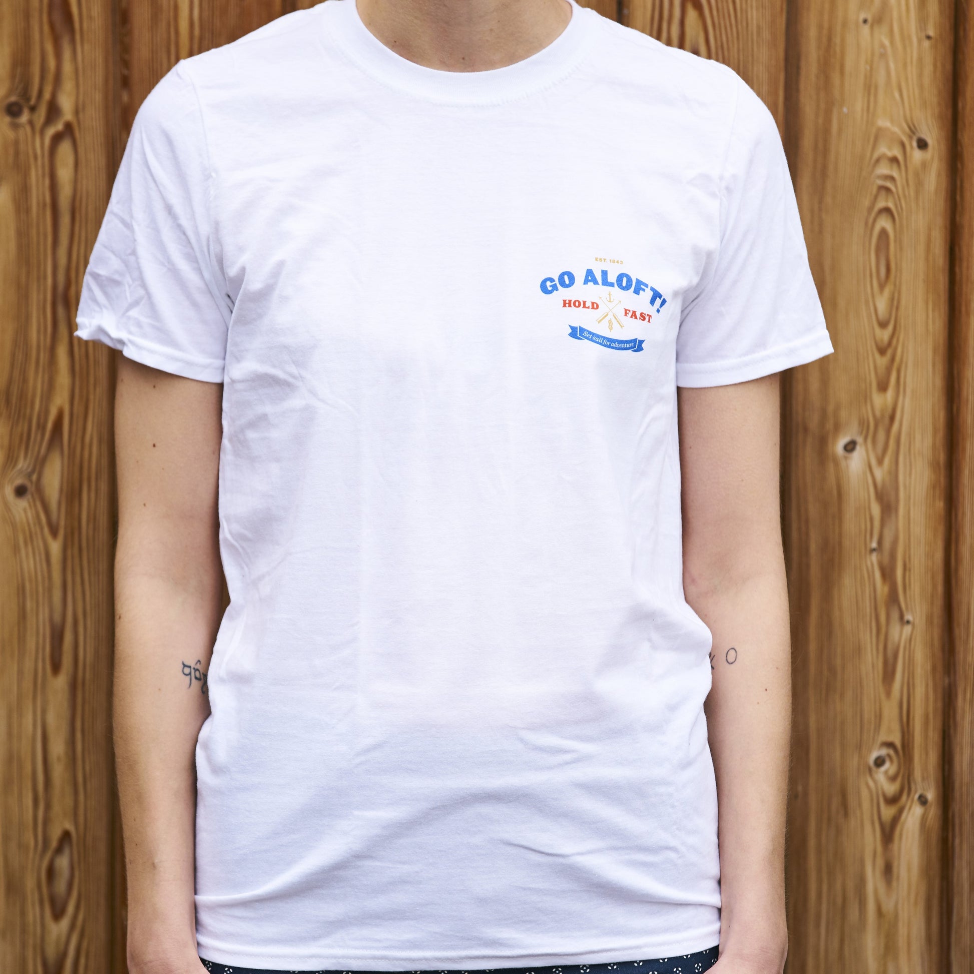 A child wearing a white crew neck t-shirt with the text 'GO ALOFT' printed on the chest.
